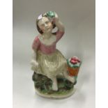 A small Staffordshire figure of a girl in seated p
