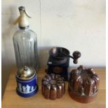 A cast iron coffee grinder together with copper je