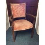 A pink upholstered Victorian armchair on tapering