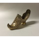 A heavy silver gilt model of a shoe with chased de
