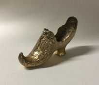 A heavy silver gilt model of a shoe with chased de