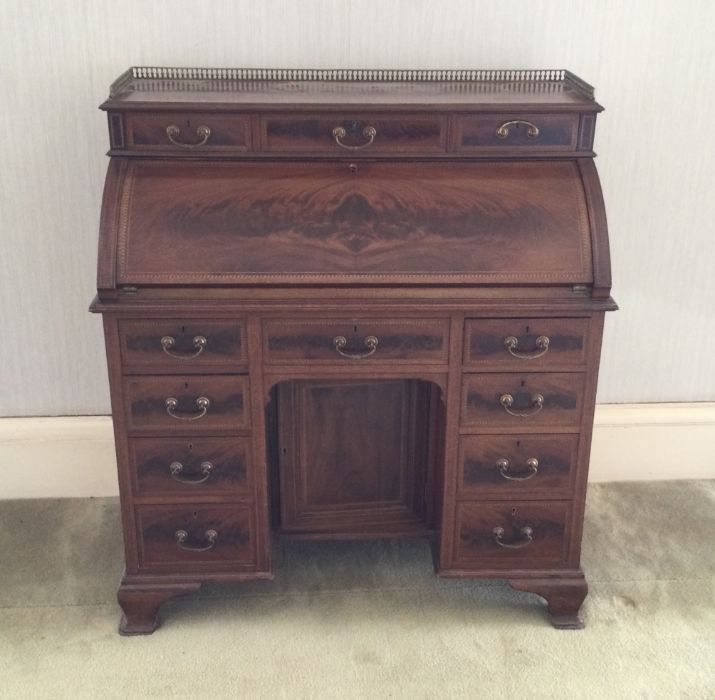 A good quality cylinder top twelve drawer bureau w