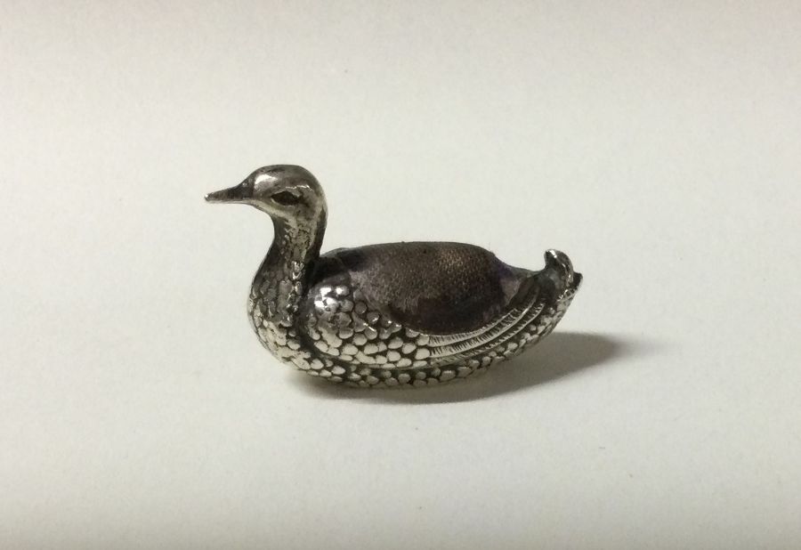 An unusual silver pic cushion in the form of a duc
