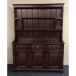 A Georgian style oak kitchen dresser with plank ba