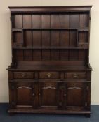 A Georgian style oak kitchen dresser with plank ba