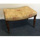 An attractive shaped upholstered stool on turned s