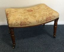 An attractive shaped upholstered stool on turned s