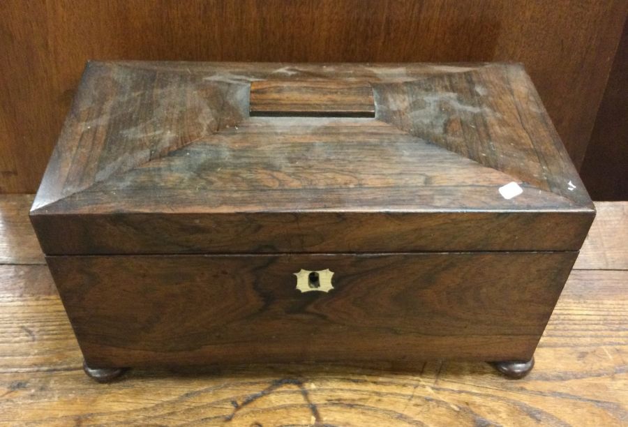 A large rosewood tea caddy of shaped form to hinge