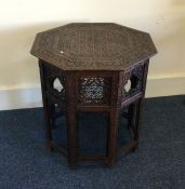 A carved Moroccan occasional table of shaped form.