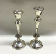 A pair of tapering silver candlesticks with reeded