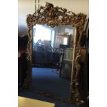 A massive gilt over mantle mirror of shaped form p