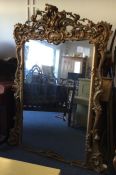 A massive gilt over mantle mirror of shaped form p