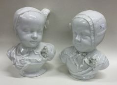 A pair of white pottery busts of children. Est. £2