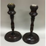A pair of turned mahogany candlesticks. Est. £15 -