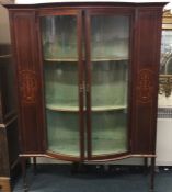 A good inlaid mahogany glass cabinet on four taper