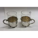 A pair of German silver and glass hot chocolate cu