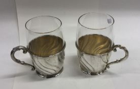 A pair of German silver and glass hot chocolate cu