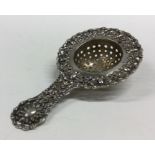 A pierced Continental silver tea strainer with emb