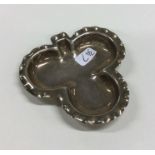 A small silver clover shaped dish with crimped rim
