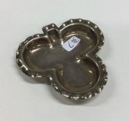 A small silver clover shaped dish with crimped rim