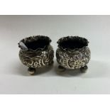 A pair of small chased silver salts with crimped r
