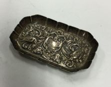 A chased silver pin dish decorated with scrolls an