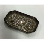 A chased silver pin dish decorated with scrolls an