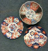 A pair of Imari wall plates together with a fruit