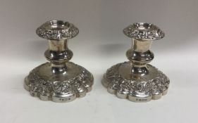A heavy pair of embossed silver candlesticks with