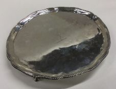 A crested silver salver of circular form on ball a