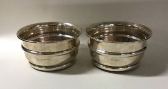 A pair of Edwardian silver wine coasters with maho
