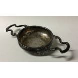 A George II silver tea strainer with reeded border