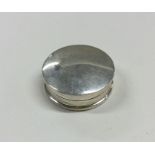 A circular silver pill box with hinged lid. Approx
