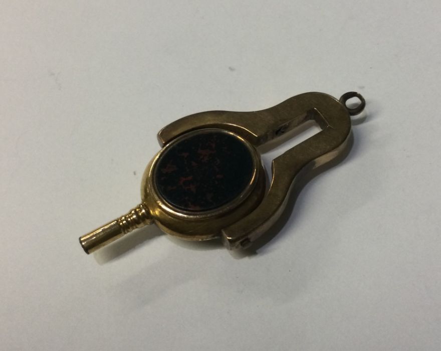 A small gold mounted swivel watch key. Approx. 9 g