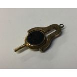 A small gold mounted swivel watch key. Approx. 9 g