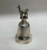A cast silver bell decorated with an animal and re