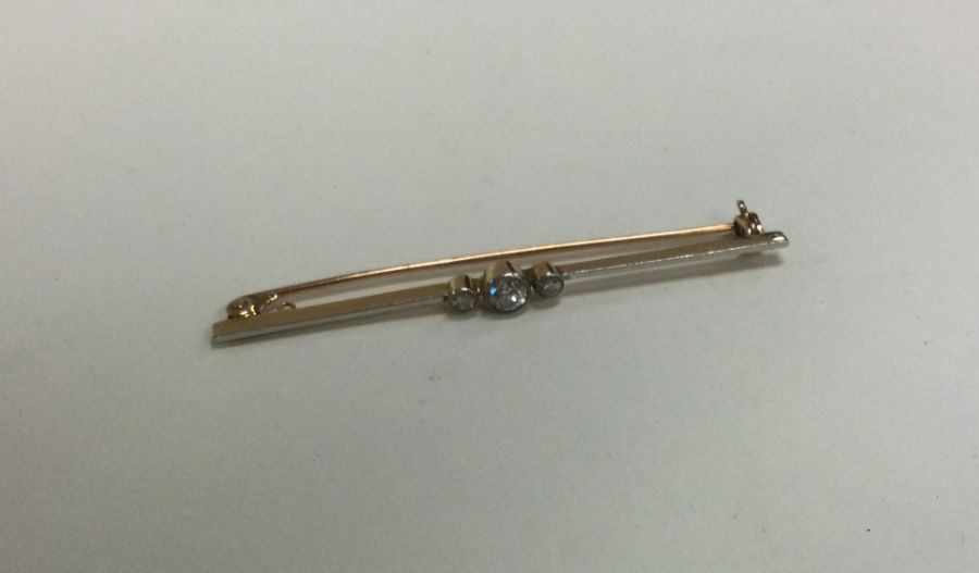 A good diamond three stone brooch on gold knife ed