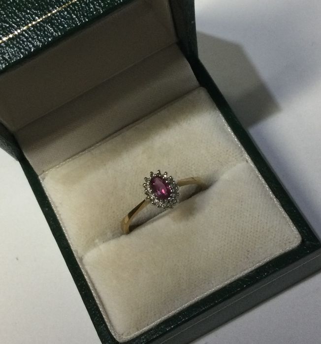 An oval diamond cluster ring in 9 carat setting. A