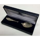 A heavy silver christening spoon with engraved dec