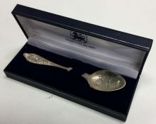 A heavy silver christening spoon with engraved dec