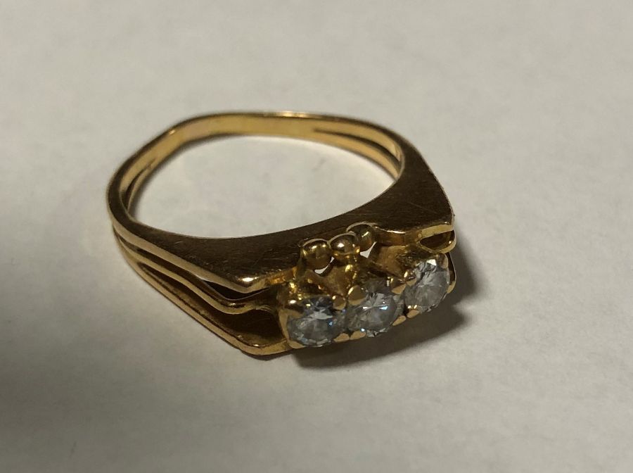An 18 carat gold and diamond three stone ring. App
