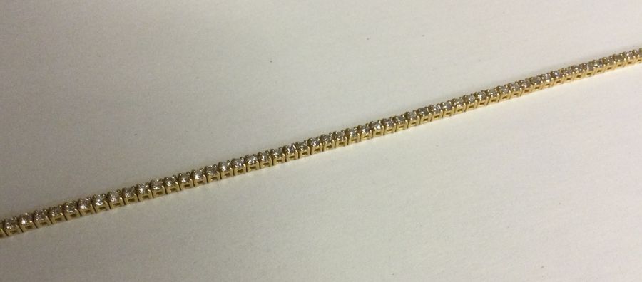 A heavy lady's 18 carat diamond line bracelet with