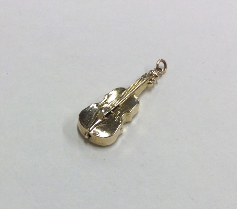 A novelty 9 carat charm in the form of a violin. A