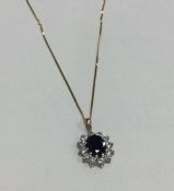 A gold pendant mounted with a sapphire cluster on