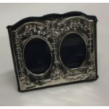 A silver mounted double picture frame decorated wi