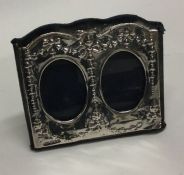 A silver mounted double picture frame decorated wi