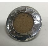 A small circular silver picture frame with easel m