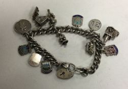 A heavy silver curb link charm bracelet decorated