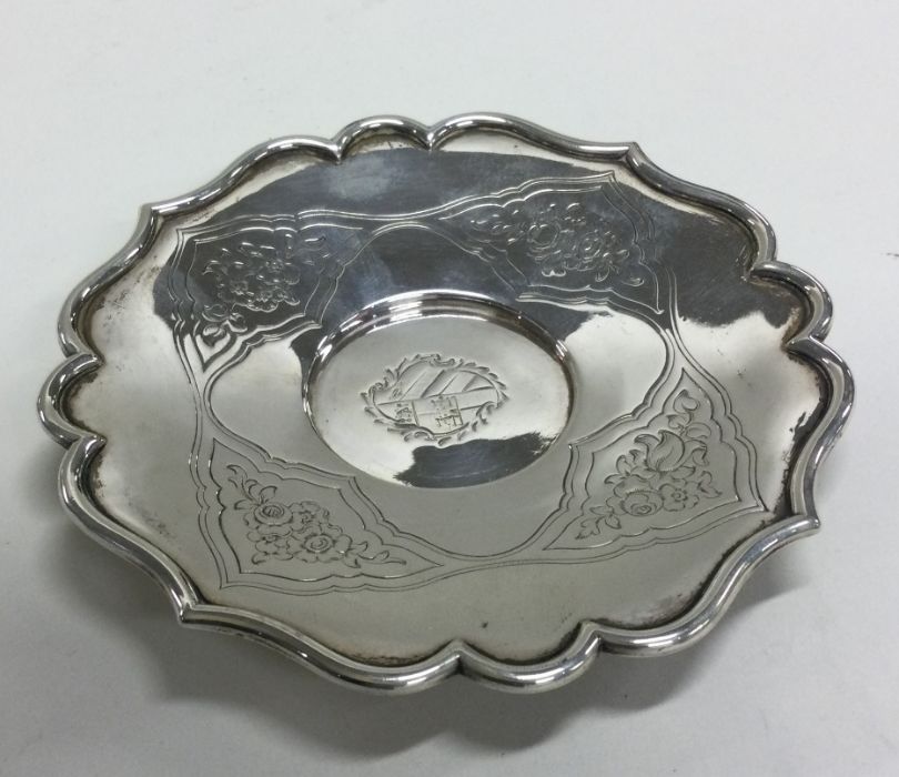 A heavy silver shaped dish decorated with flowers