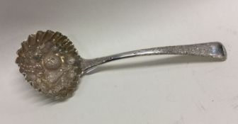 A pierced silver sauce ladle decorated with fruit.